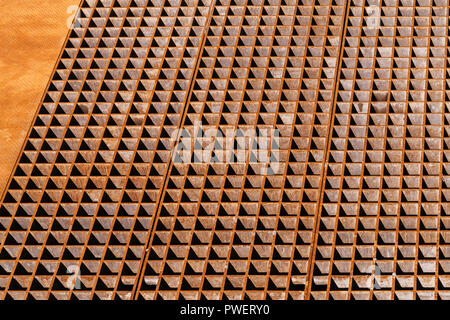 Rusty industrial flooring with drainage grate sections, background texture Stock Photo