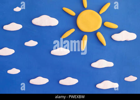 Beautiful sunny day. Sun and clouds on a blue sky. Scene is made out of play clay. Stock Photo