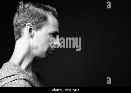 Rebellious man against black background in black and white Stock Photo