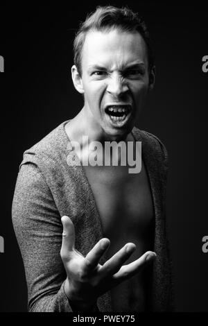 Rebellious man against black background in black and white Stock Photo