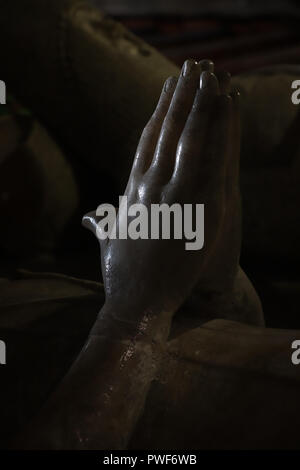 Dramatically lit elegant hands in prayer from the 14th century alabaster effigy of Lady Katharine's tomb in St. Mary the Virgin Church, Berkeley, UK Stock Photo