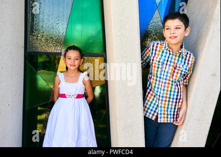 MERIDA, YUC/MEXICO - NOV 18, 2017: Portrait of mexican brother and sister outside church, after attending the baptism of their baby twin cousins Stock Photo