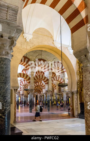 Cordoba, Spain - June 20, 2017: Pillars and arches with red and white stripes in the interior of Great Mosque of Cordoba and the Mezquita, Cathedral o Stock Photo