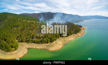 Aerial panorama of forest fire on shores of Blowering Reservoir, NSW, Australia Stock Photo