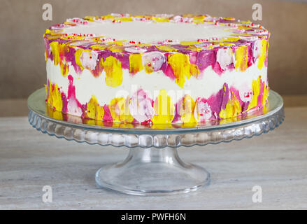 White Birthday cake with colorful Sprinkles over a light background. Stock Photo