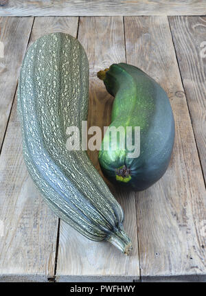 Two green ripe zucchini on a wooden background. Rustic style Stock Photo