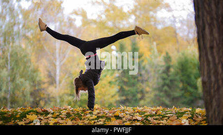 Beautiful athletic young girl gymnast in sportswear, working out, element  of gymnastics, doing the splits. wooden and concrete background. Sport Stock  Photo - Alamy