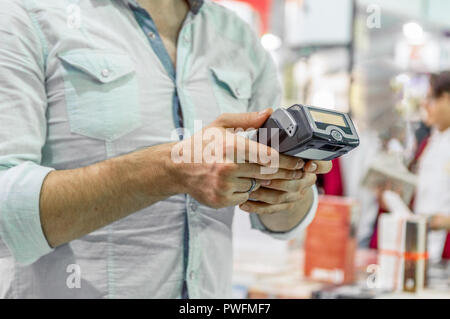 Caucasian seller man holding card machine or POS terminal in his hands Stock Photo