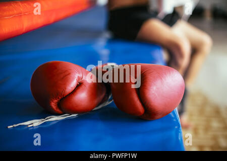 Red boxing gloves on boxing ring in gym. Sports equipment for training Stock Photo