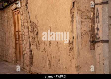 Outside mud wall and wooden door of oldest house in Old Town Tashkent, Uzbekistan. Stock Photo