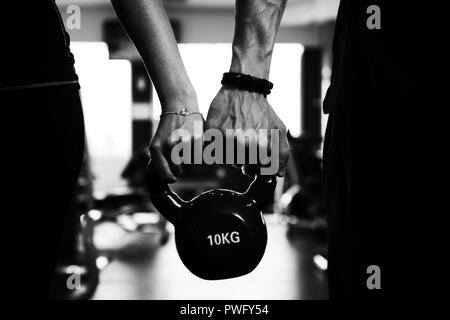 Close-up of Couple Holding Kettlebell Showing Some Love Stock Photo