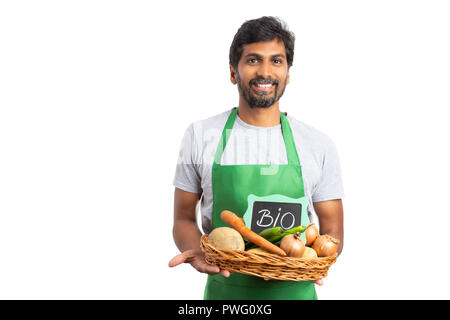 Indian hypermarket or supermarket employee with happy exptession holding grocery basket with bio text on sign isoalted on white Stock Photo