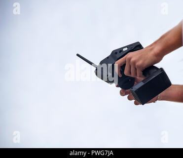 A man holds a radio-controlled remote in the hands of the car, competitions in radio-controlled models, toys, remote control, copy-space Stock Photo