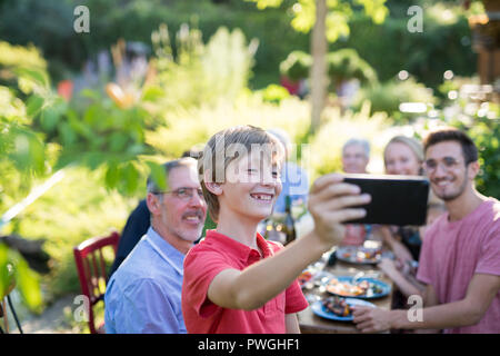 during a bbq a young boy does a selfie with the whole family Stock Photo