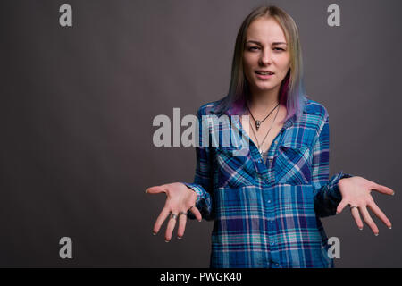 Young beautiful rebellious woman with multicolored hair against  Stock Photo