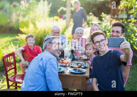 during a bbq a boy does a selfie with the whole family Stock Photo