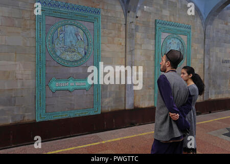 Uzbek passengers looking at mural from the Soviet era decorating Alisher Navoi Station at the Tashkent underground Metro in Uzbekistan. The Tashkent Metro built in the former USSR is one of only two subway systems currently operating in Central Asia and its stations are among the most ornate in the world. Stock Photo