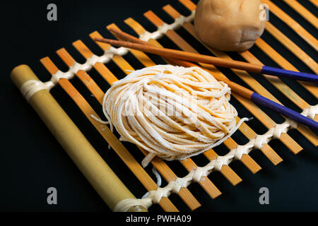 Food fresh raw homemade oriental Asian, Chinese egg noodles by organic eggs and all purpose flour on a bamboo tray Stock Photo