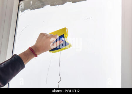 washing and cleaning the window with a squeegee. Washing the window with a magnetic brush. Simultaneous cleaning of the window on both sides. Stock Photo