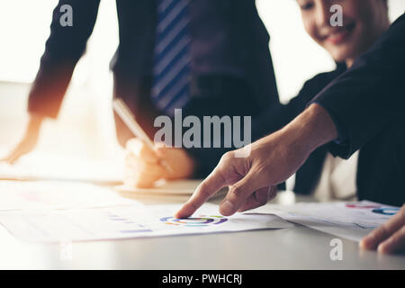 businessmen working and point on graph financial diagram and analysis documents on office table Stock Photo