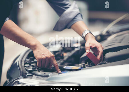 Businessmen help businesswomen check and repair broken cars Stock Photo