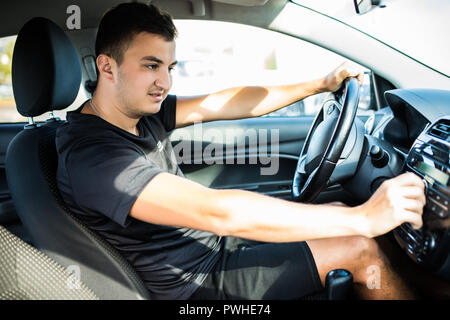 Man is going to drive, looking for some nice music Stock Photo
