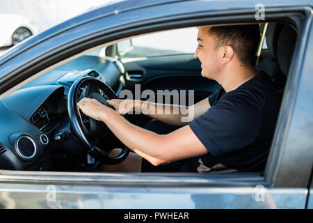 Side view of angry man in suit driving car and beeps Stock Photo