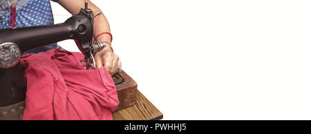 Indian Senior  women sitting cross-legged making clothes with old sewing machine Stock Photo