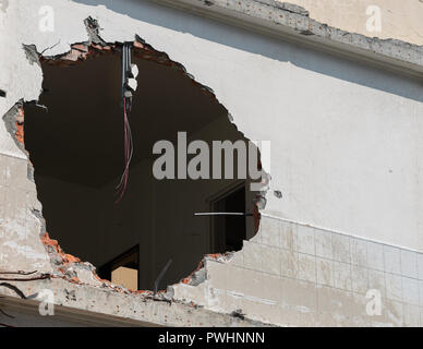 Huge hole with wires hanging in a building wall and copy space Stock Photo