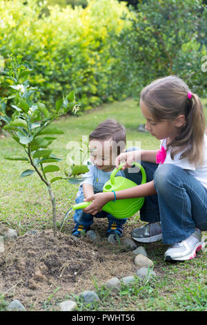 Happy Children Planting Garden In The Park Stock Photo