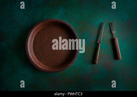 Ceramic tableware pottery plate on grunge green background Stock Photo