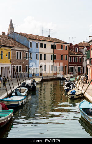 A view down a canal with colourful houses and boats in Burano, Venice, Italy Stock Photo