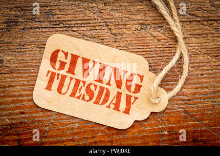 Giving Tuesday sign - a paper price tag with a twine on a rustic wood Stock Photo