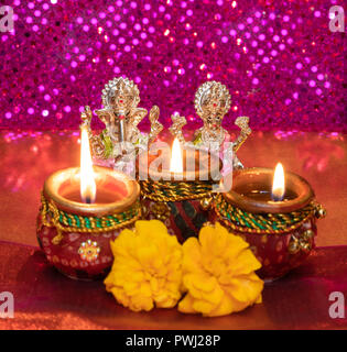 Diwali Background Showing Lit Lamps Against Hindu Idols of Deities Lakshmi and Ganesh Stock Photo