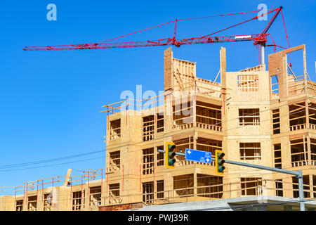 Six storey frame building under construction on concrete foundation bed ...