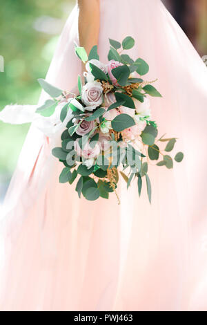 bride's hands hold beautiful bridal bouquet outdoor Stock Photo