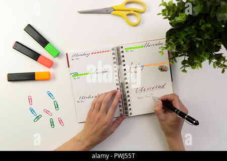 Woman's hands with pen writing in planner. Modern office desk. Working, writing concept Stock Photo