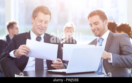 business partners discussing a new project, sitting in the lobby of the office. Stock Photo