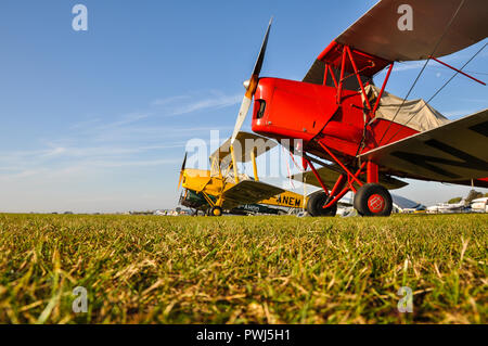 Tiger Moth biplanes sitting on the grass at Duxford airfield. de Havilland DH82 Tiger Moth plane. Vintage aircraft. Planes. Airplanes. Aviation Stock Photo