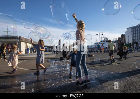 Children are playing with soap bubbles at Aker brygge in Oslo, Norway Stock Photo