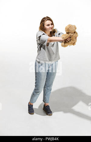 Photo of pretty woman hug cute soft toy, closeup portrait of female with teddy bear and on white background, Valentine day, love and happiness concept Stock Photo