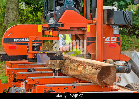WOOD MIZER A TRANSPORTABLE SAWMILL IN ACTION SAWING A LOG OF WOOD Stock Photo