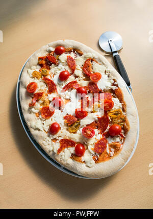Oval pizza ready and prepared for the oven - mozzarella cheese and tomatoes Stock Photo