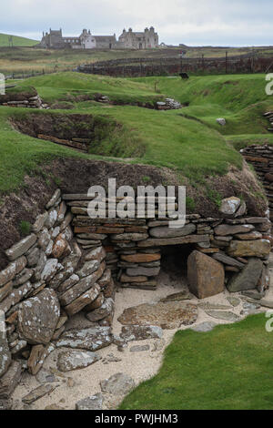 5000 years of human habitation, from tiny houses of Skara Brae (3100 BC) to Skaill House (1620 AD) in one photo, on Orkney Mainland, Scotland, UK. Stock Photo