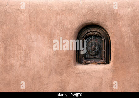 Old adobe wall security window in Santa Fe, New Mexico. Stock Photo
