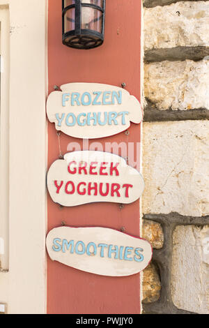 Sign advertising frozen yoghurt, greek yoghurt and smoothies at the pretty coastal village of Kassiopi in north east Corfu Stock Photo