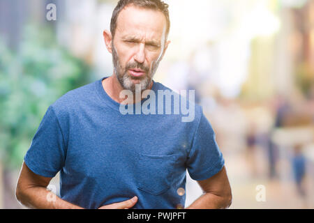 Middle age hoary senior man over isolated background with hand on stomach because indigestion, painful illness feeling unwell. Ache concept. Stock Photo