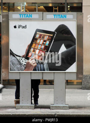An advertisement for the Apple iPad on the back of a telephone kiosk in the city of Manhattan, New York. Stock Photo
