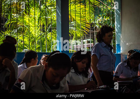 teacher helping students in guatemalan college Stock Photo