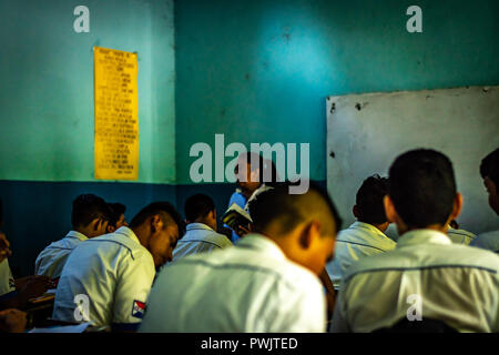 teacher helping students in guatemalan college Stock Photo